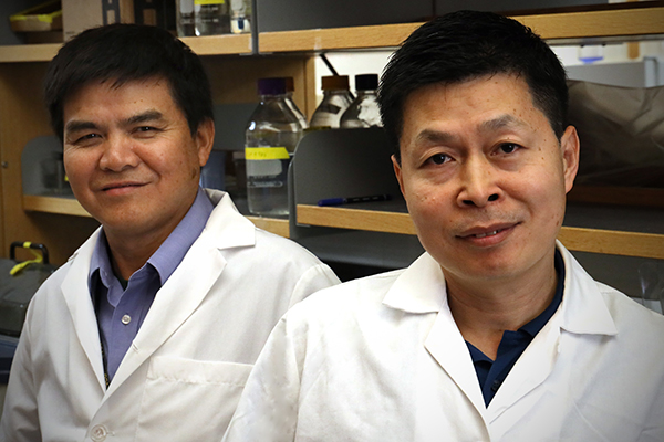 Drs. Shawn Wang and Frank Fang standing together in a lab