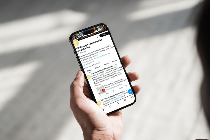 Phone with Massey X social media feed screen grab