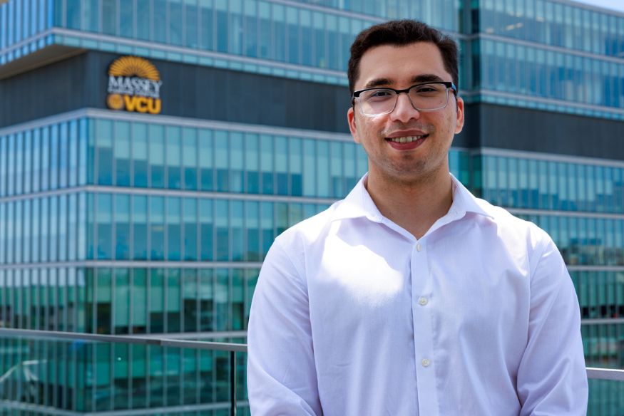 Headshot of young man, Eren Okandan, in front of building with Massey logo