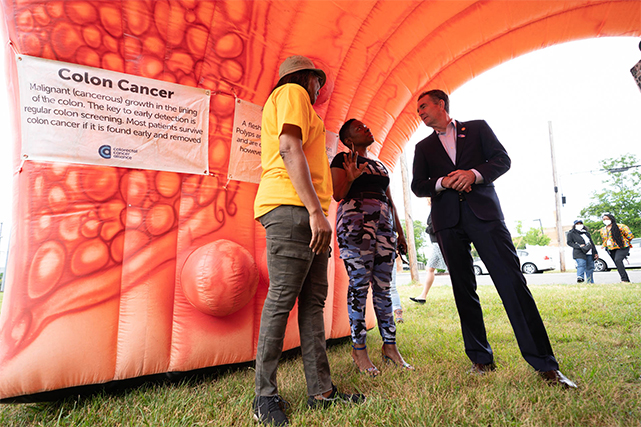 Former-governor Northam speaks with residents inside an inflatable colon