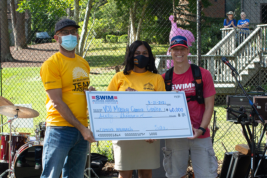 Massey doctor, Khalid Matin, M.D. (left), receiving a check from Swim Across America
