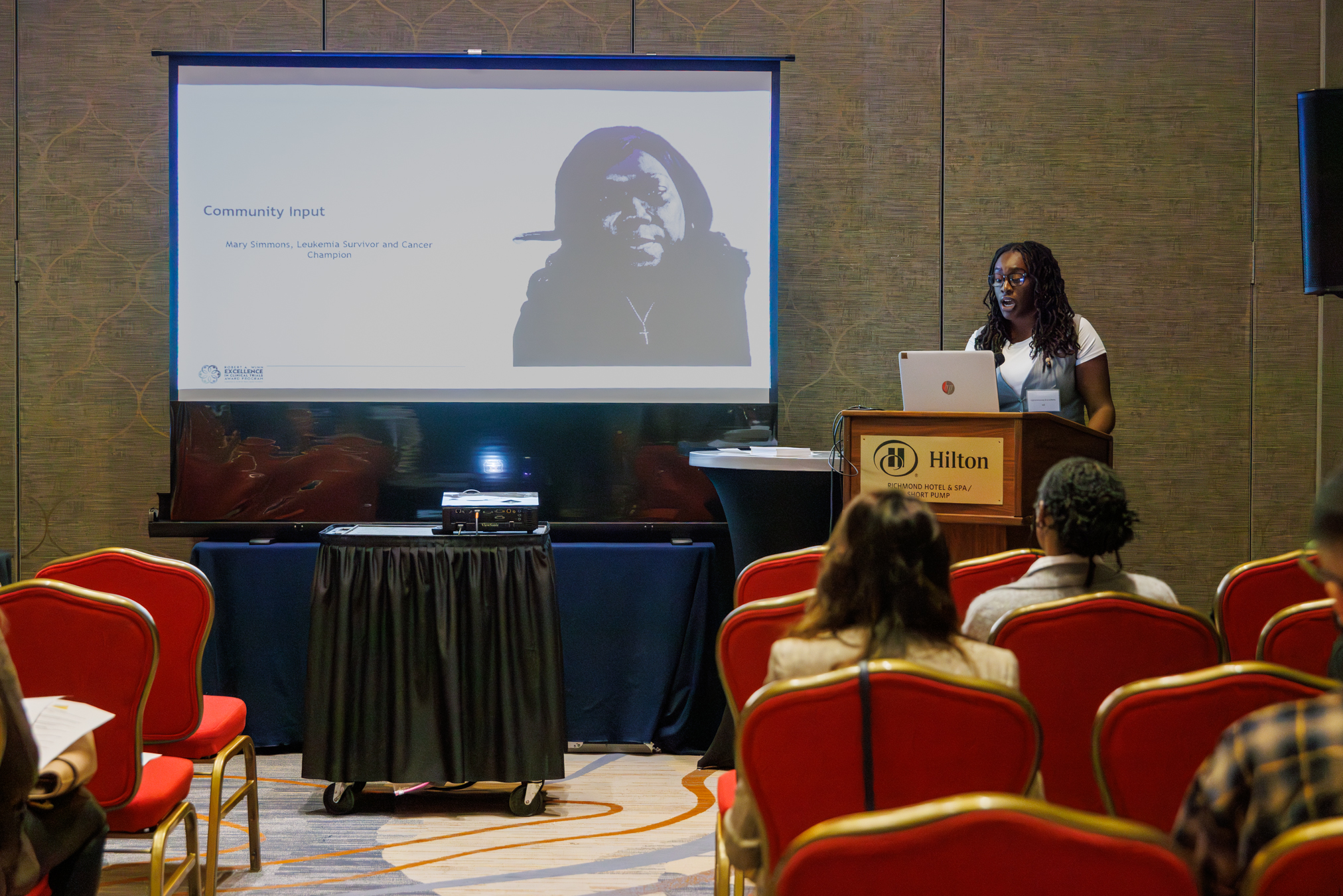 Woman standing at podium in front of presentation screen