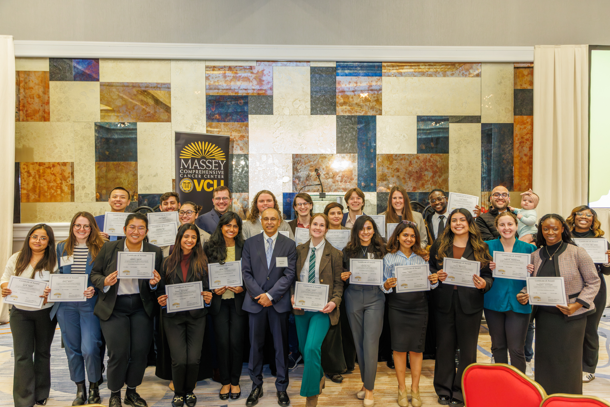 Group of young adults standing and holding certificates