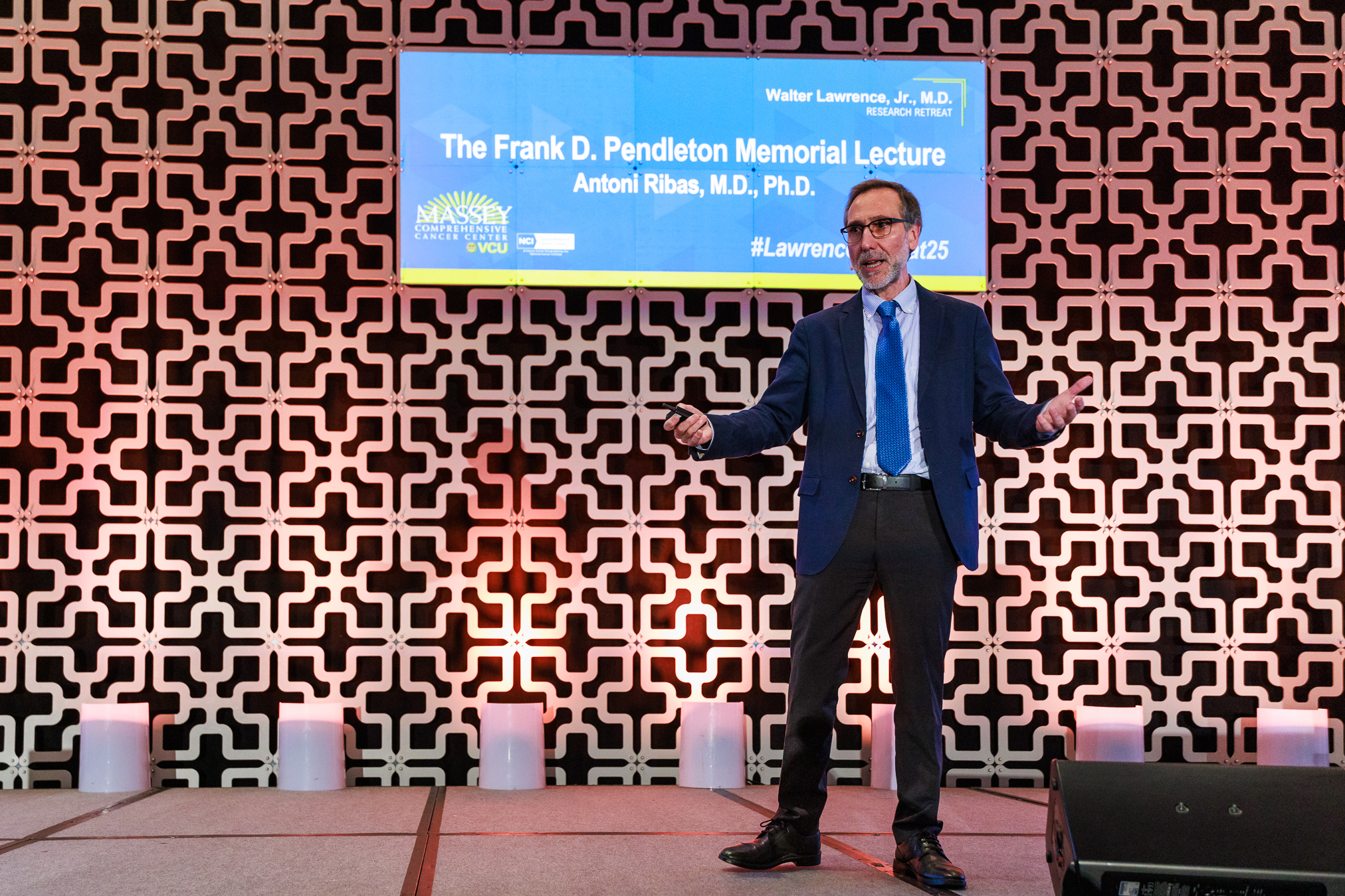 Antoni Ribas, M.D., Ph.D. on stage presenting with screen behind him labeled with his name