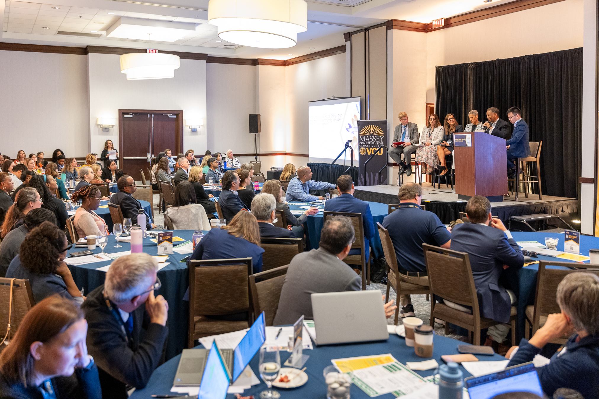 Photo of Massey affiliates speaking on stage at Virginia Health District Directors Meeting
