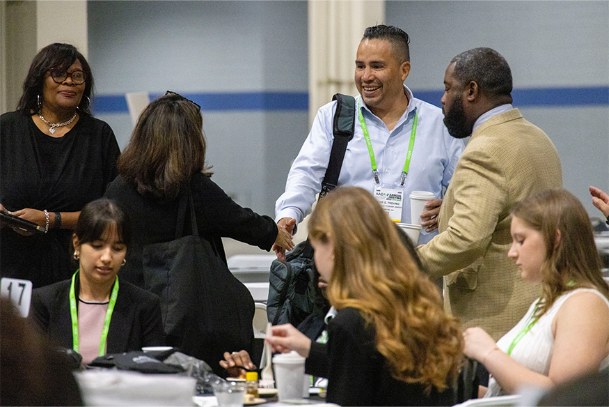 Jose Trevino, M.D. shaking hands with conference attendee