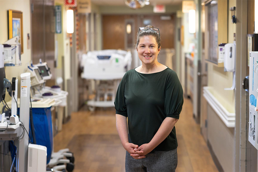 Photo of Kelly Smith posed with inside of hospital in the background