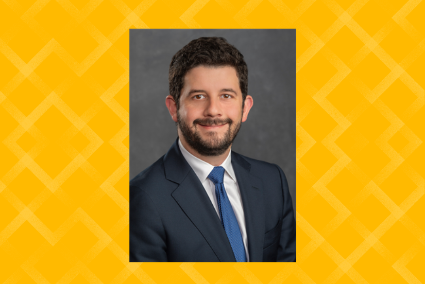 Professional headshot of Ricardo Bello on yellow background