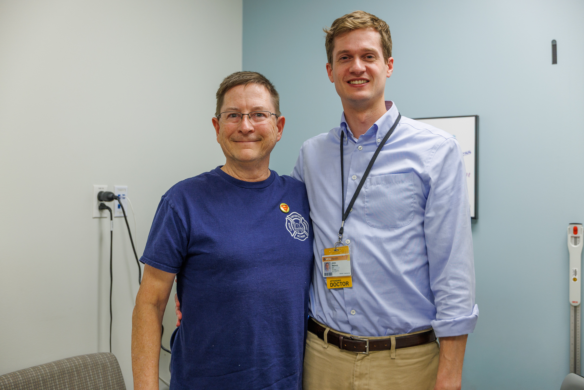 Two men pictured beside each other in a doctors office examination room
