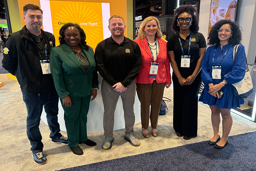 Radiant smiles from team members representing Massey Comprehensive Cancer Center and VCU at the Massey event booth at the 2026 ASCO Annual Meeting in Chicago