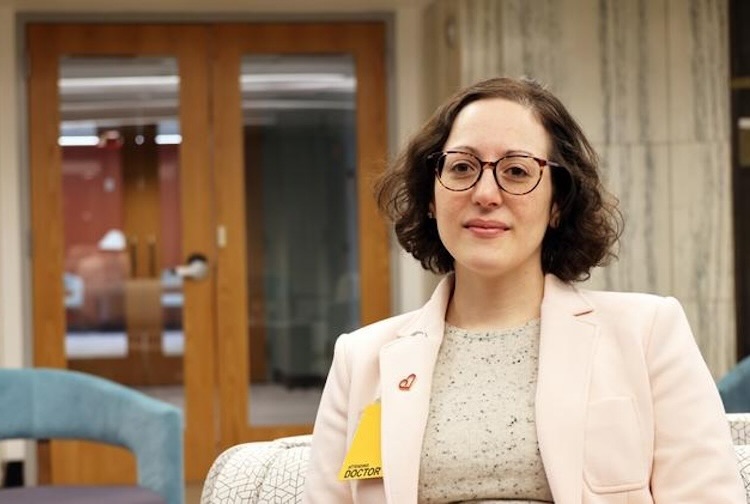 A professional headshot of Dr. Wendy Bottinor, a woman with dark curly hair and glasses, wearing a light pink blazer over a grey top in an office setting.