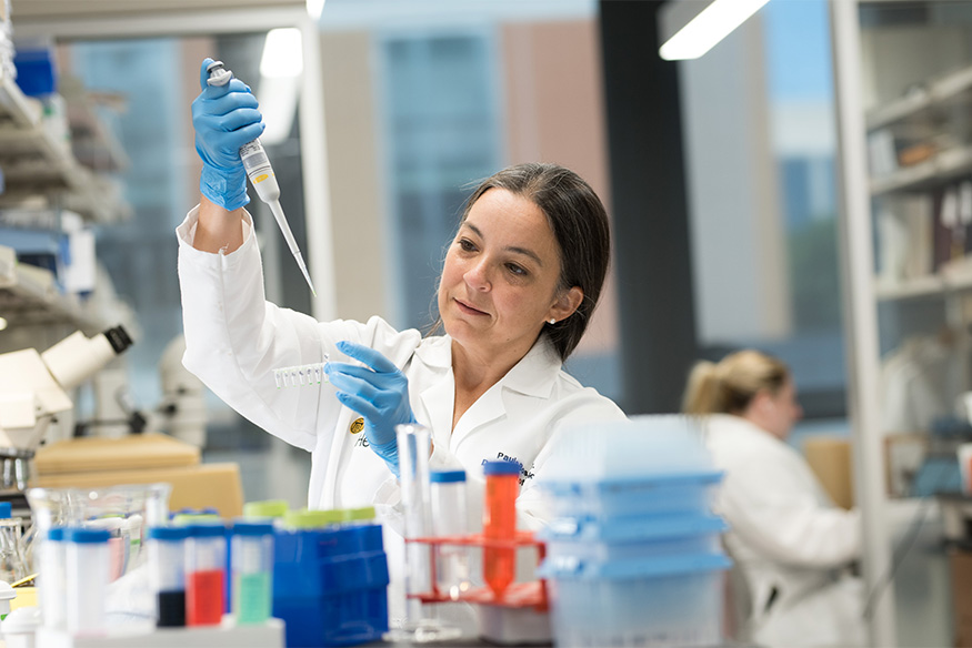 Paula Bos in the laboratory with a pippette