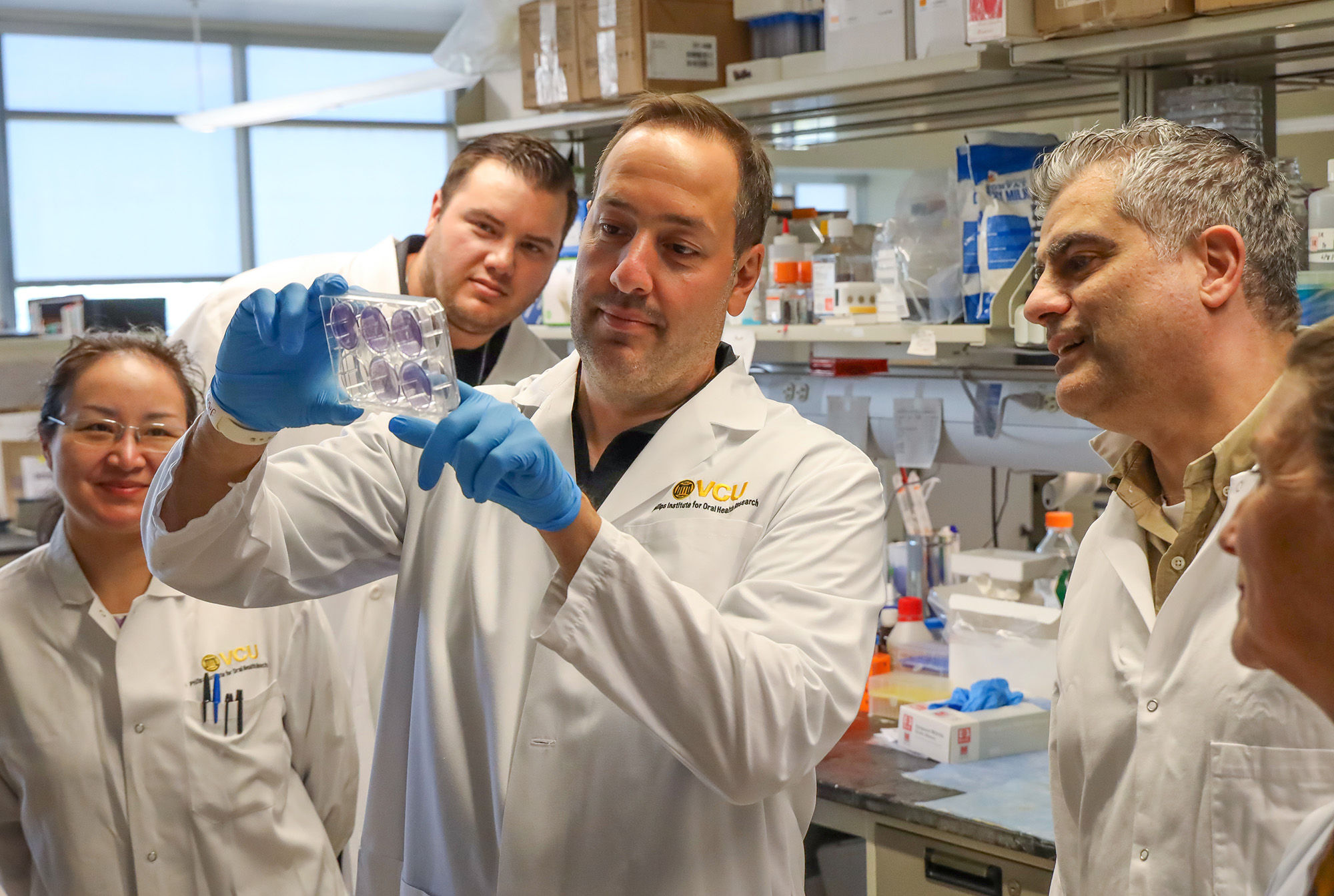Anthony Faber, Ph.D with researchers looking at sample