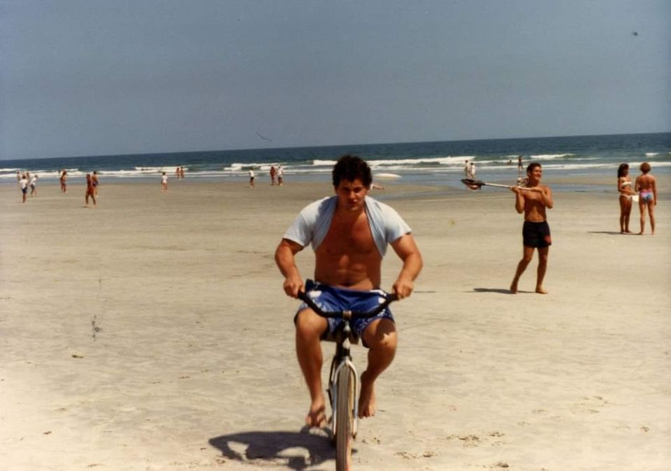 Mike Pascucci riding a bike on the beach
