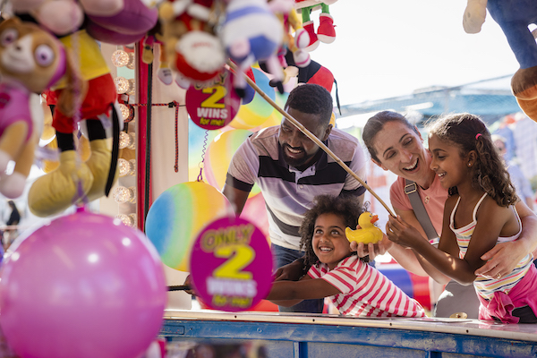 Parents and two children play a carnival game with prizes